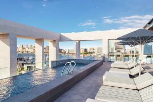 a rooftop pool with chairs and an umbrella on a building at Canopy by Hilton Dubai Al Seef in Dubai