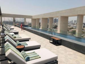 Canopy by Hilton Dubai Al Seef في دبي: مسبح فوق مبنى به مسبح
