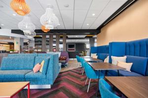 a waiting room with blue furniture and tables at Tru By Hilton Portland Airport, Or in Portland