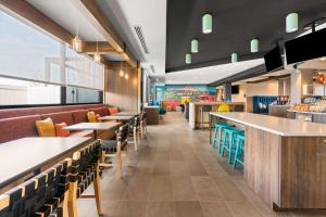 um restaurante com mesas e cadeiras e um bar em Tru By Hilton Portland Airport, Or em Portland