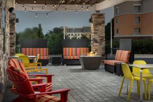 patio z kolorowymi krzesłami i stołami oraz miejscem na ognisko w obiekcie Home2 Suites By Hilton Columbus Polaris w mieście Columbus