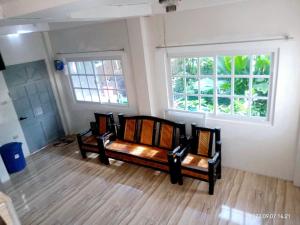 a living room with two benches and two windows at Budget room with split type air-condition in San Fernando