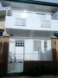 una casa con una puerta blanca y una valla en Budget room with split type air-condition, en San Fernando