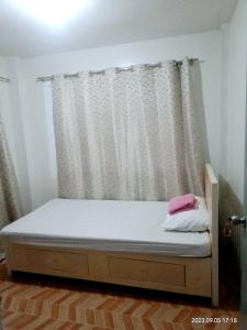 Bett in einem Zimmer mit Fenster in der Unterkunft Budget room with split type air-condition in San Fernando