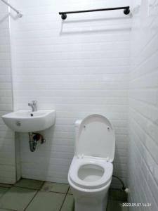 a bathroom with a white toilet and a sink at Budget room with split type air-condition in San Fernando