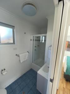 NRMA Shellharbour Beachside Holiday Park في شلهاربور: حمام أبيض مع دش ومغسلة