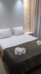 a bed with two white towels on top of it at Villa dos Diamantes - 16 in Porto Seguro