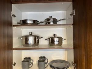 two pots and pans on a shelf in a kitchen at Departamento Central Ejecutivo- Apart Hotel in Calama