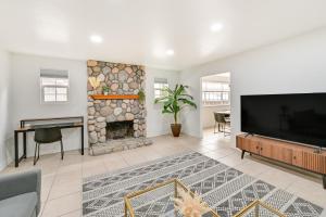a living room with a fireplace and a flat screen tv at Sleek San Diego Vacation Rental with Private Patio! in San Diego