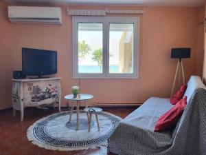 a living room with a couch and a tv at Afentis Apartment in Chios