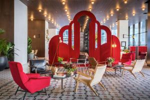 a lobby with red chairs and tables in a building at Canopy by Hilton Madrid Castellana in Madrid