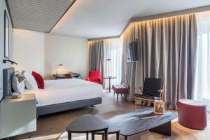 ein Hotelzimmer mit einem Bett, einem Tisch und Stühlen in der Unterkunft Canopy by Hilton Madrid Castellana in Madrid