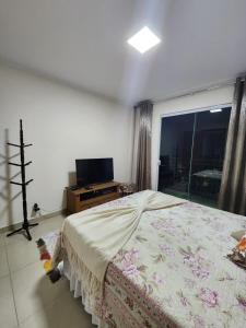 um quarto com uma cama, uma televisão e uma janela em Casa em São Lourenço-MG em São Lourenço