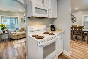 a kitchen with a white stove top oven next to a living room at Walk to Beach Hampton Home with Grill! in Hampton