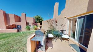 a patio with a grill and chairs on the side of a house at Adventure Villa #3282 in Moab