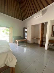 a bedroom with a bed and a table in it at El Homestay Bali in Nusa Dua