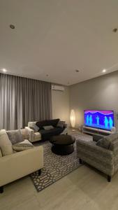a living room with two couches and a flat screen tv at شقة انيقة باثاث فاخر in Riyadh