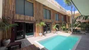 a swimming pool in front of a house at Harmonia Tulum in Tulum