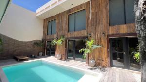 a house with a swimming pool in front of it at Harmonia Tulum in Tulum