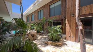 a building with a bunch of plants in front of it at Harmonia Tulum in Tulum