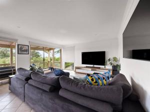 a living room with a large couch and a flat screen tv at Whale Watch Augusta Family Retreat in Augusta