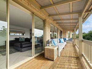 a screened in porch with a couch and furniture on it at Whale Watch Augusta Family Retreat in Augusta