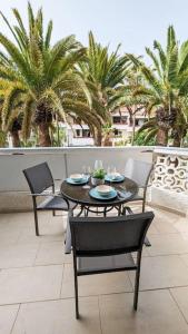 un tavolo e sedie su un patio con palme di Apartamento Tenerife Sur a Playa de las Americas