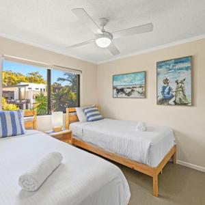 a bedroom with two beds and a window at The Mirage Resort Alexandra Headland in Alexandra Headland
