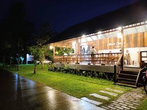a building with people standing outside at night at บ้านวารีชีวา WareeCheewa in Ban Muai +39 photos