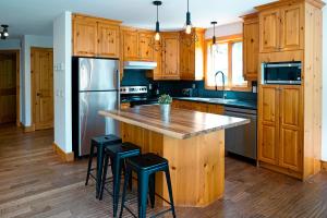 a kitchen with wooden cabinets and a stainless steel refrigerator at Le 583 Stoneham CITQ#239,960 in Stoneham