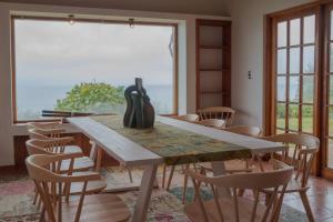 mesa de comedor con sillas y ventana grande en Casa de Lujo frente al Mar en Buchupureo-Curanipe, en Curanipe