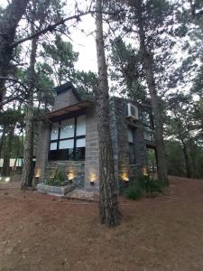 una casa con árboles delante de ella en Basowato Beach en Mar de las Pampas