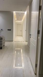 a white hallway with a door and a room at Luxury Apartment in Riyadh