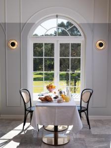 ein Esszimmer mit einem Tisch mit Essen und einem Fenster in der Unterkunft Le Mas Barossa in Rowland Flat