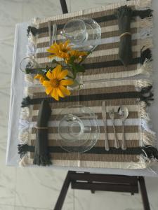 a table with a napkin with flowers and cutlery at Pousada Artelai in Angra dos Reis