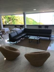 a living room with a couch and tables and chairs at Pousada Artelai in Angra dos Reis