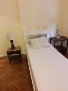 sypialnia z białym łóżkiem i dwoma stołami w obiekcie Posto6 w mieście Rio de Janeiro
