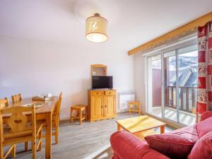 a living room with a dining room table and a television at Appartement Peyragudes, 2 pièces, 6 personnes - FR-1-695-3 in Germ