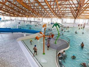 duży kryty basen z ludźmi w wodzie w obiekcie Appartement lumineux avec balcon, 2 chambres, parking privé, proche gare à Saint-Chamond - FR-1-496-272 w mieście Saint-Chamond