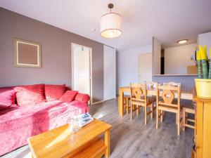 a living room with a red couch and a table at Appartement cosy pour 6 personnes avec balcon, parking et accès aux pistes - FR-1-695-9 in Germ