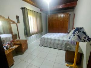 um quarto com uma cama, um espelho e um candeeiro em Casa de campo Bela Vista em Itamonte
