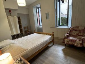sypialnia z łóżkiem, krzesłem i oknem w obiekcie Appartement T2 bis Cauterets - 50m télécabine et Thermes - 4/6 pers - parking gratuit - FR-1-234-300 w mieście Cauterets