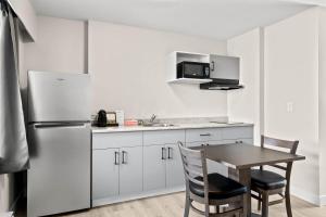a kitchen with a table and a refrigerator at The Vista Inn in Kamloops