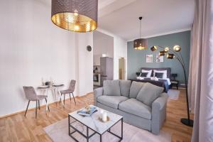 un soggiorno con divano e letto di Historisches Deluxe Apartment im Marianum a Neuss