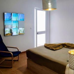 a bedroom with a bed and a chair and a television at Thelighthouse Porto Santo in Porto Santo