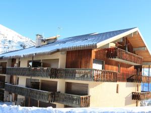 ein Gebäude mit Balkonen und einem schneebedeckten Dach in der Unterkunft Appartement Auris, 1 pièce, 3 personnes - FR-1-297-326 in Auris