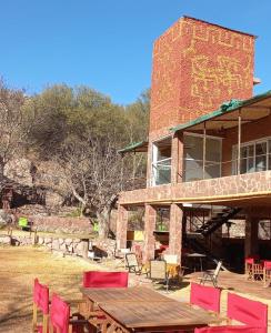 una mesa de picnic y sillas frente a un edificio en Hostal La Casa en Aicuña