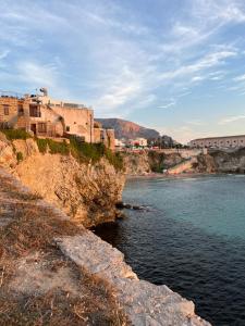 a view of a body of water with buildings on a cliff at Sweet House Sicily in Terrasini