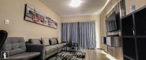 a living room with a couch and a television at Banbury Estate luxury apartment in Johannesburg