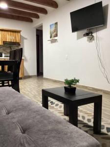 a living room with a couch and a table with a tv at Apartamento en Rionegro cerca del aeropuerto in Rionegro
